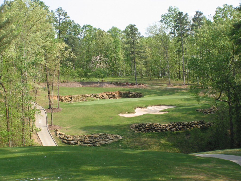 view of golf course green with bunker