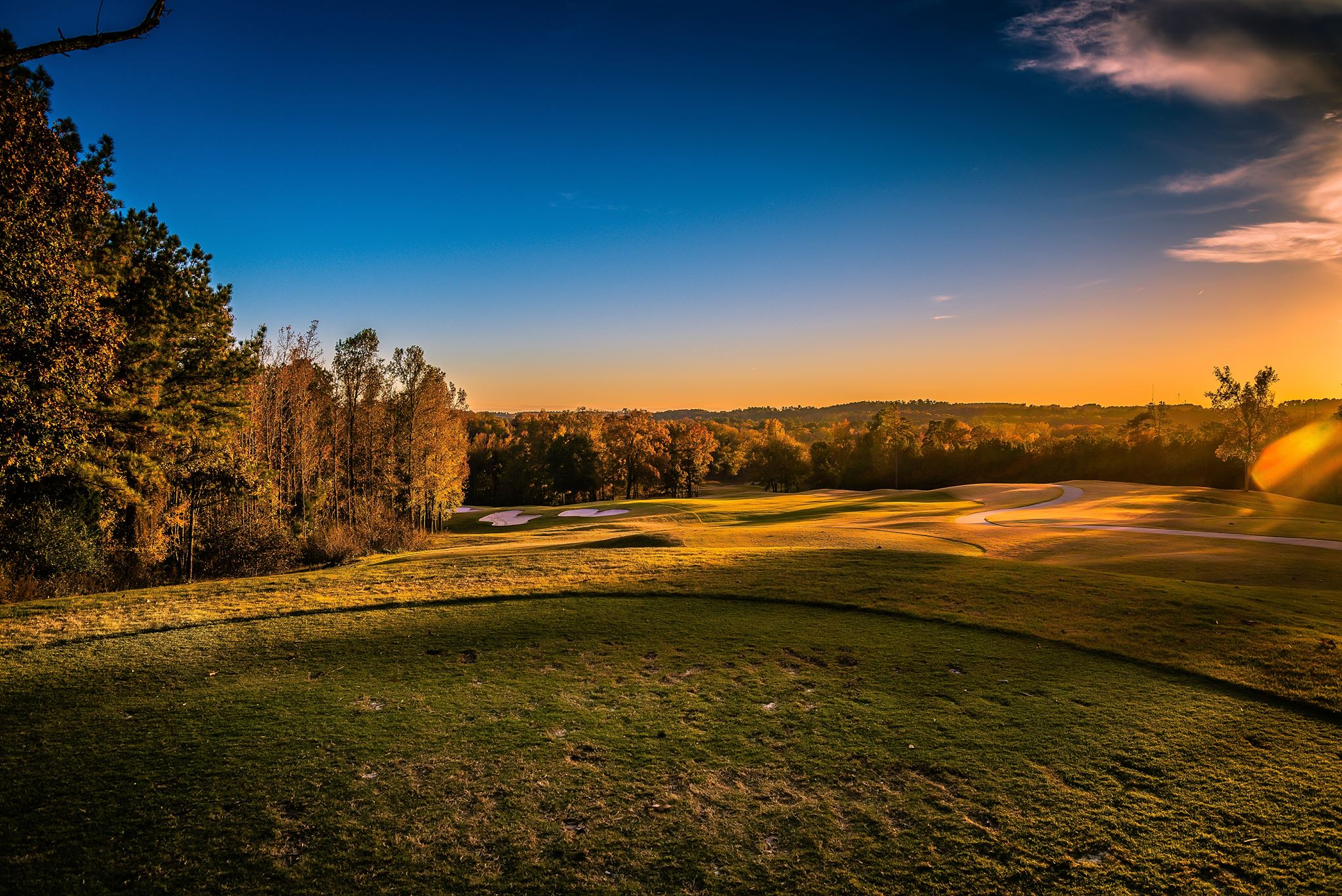 View of golf course with blue sun sky